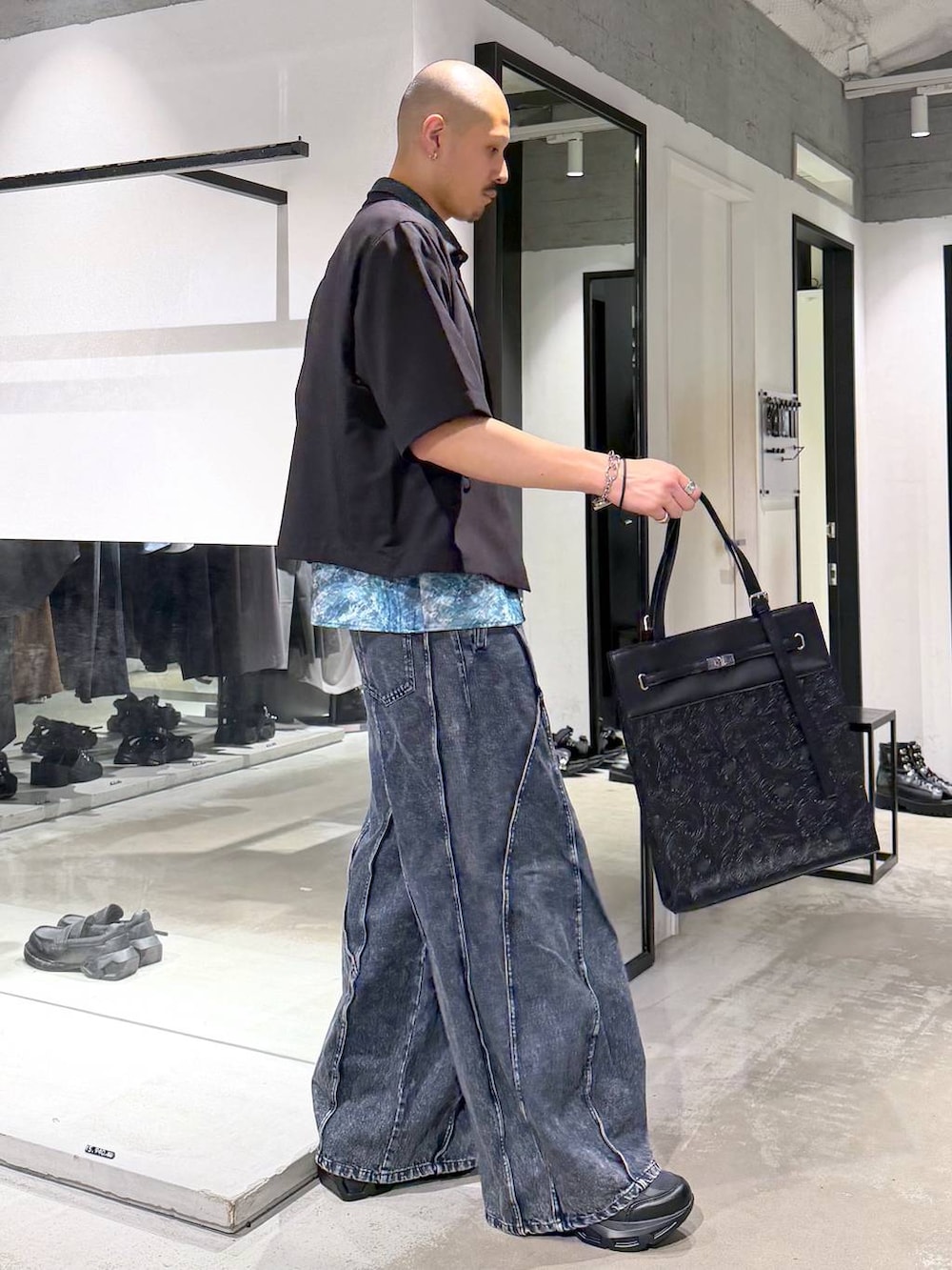 ブラック系のスニーカー、ブルー系のデニムパンツ、ブルー系のシャツ/ブラウスを着用したメンズの夏コーディネートの4枚目の写真