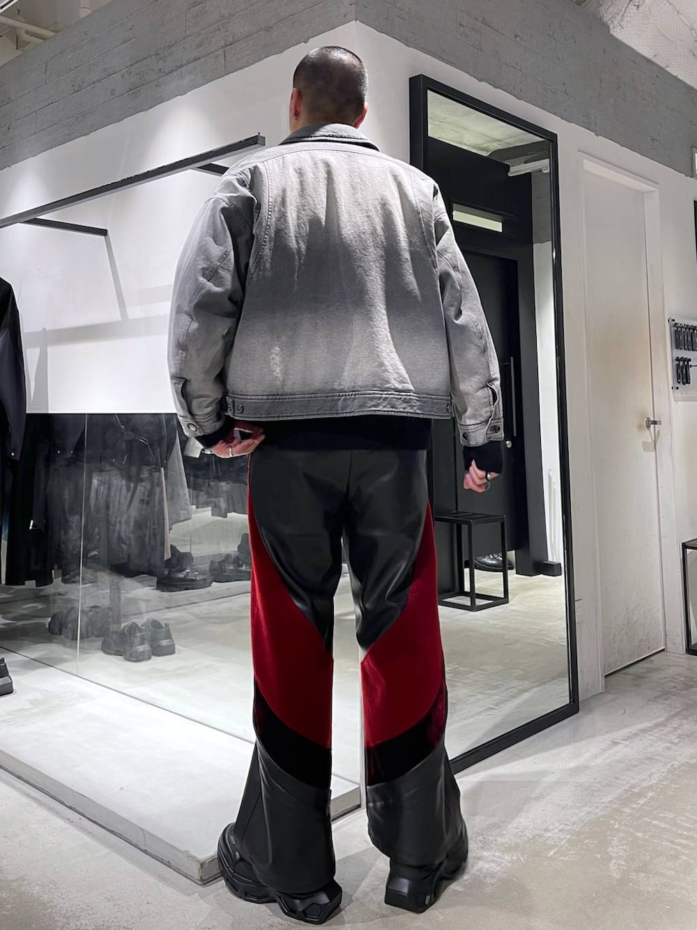 ブラック系のスニーカー、レッド系のその他パンツ、グレー系のブルゾンを着用したメンズの冬コーディネートの3枚目の写真