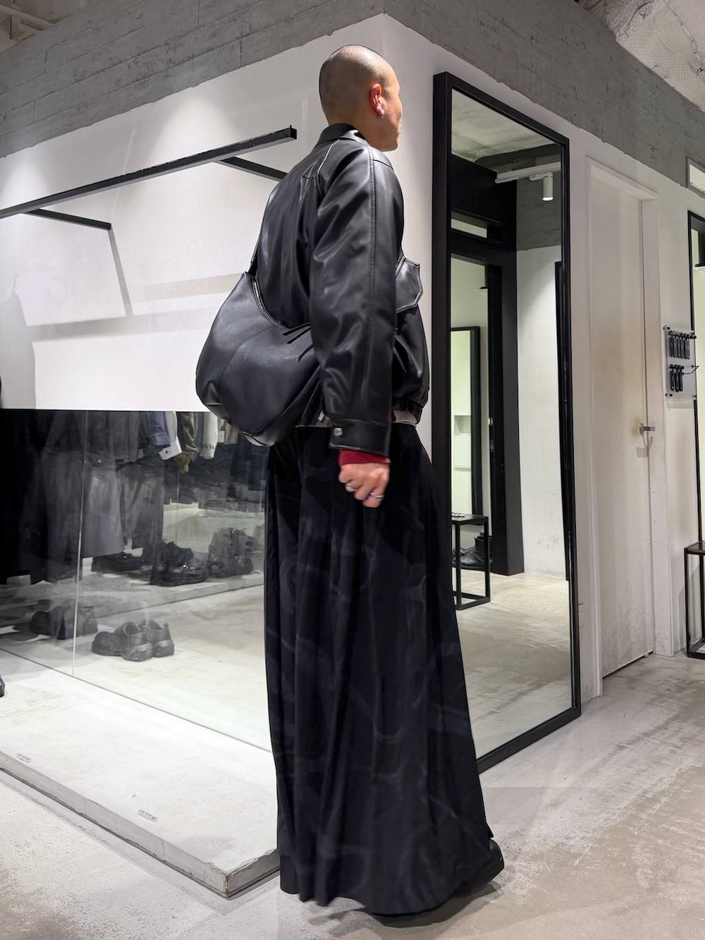 ブラック系のブルゾン、グレー系のその他パンツ、レッド系のカーディガン/ボレロを着用したメンズの冬コーディネートの4枚目の写真