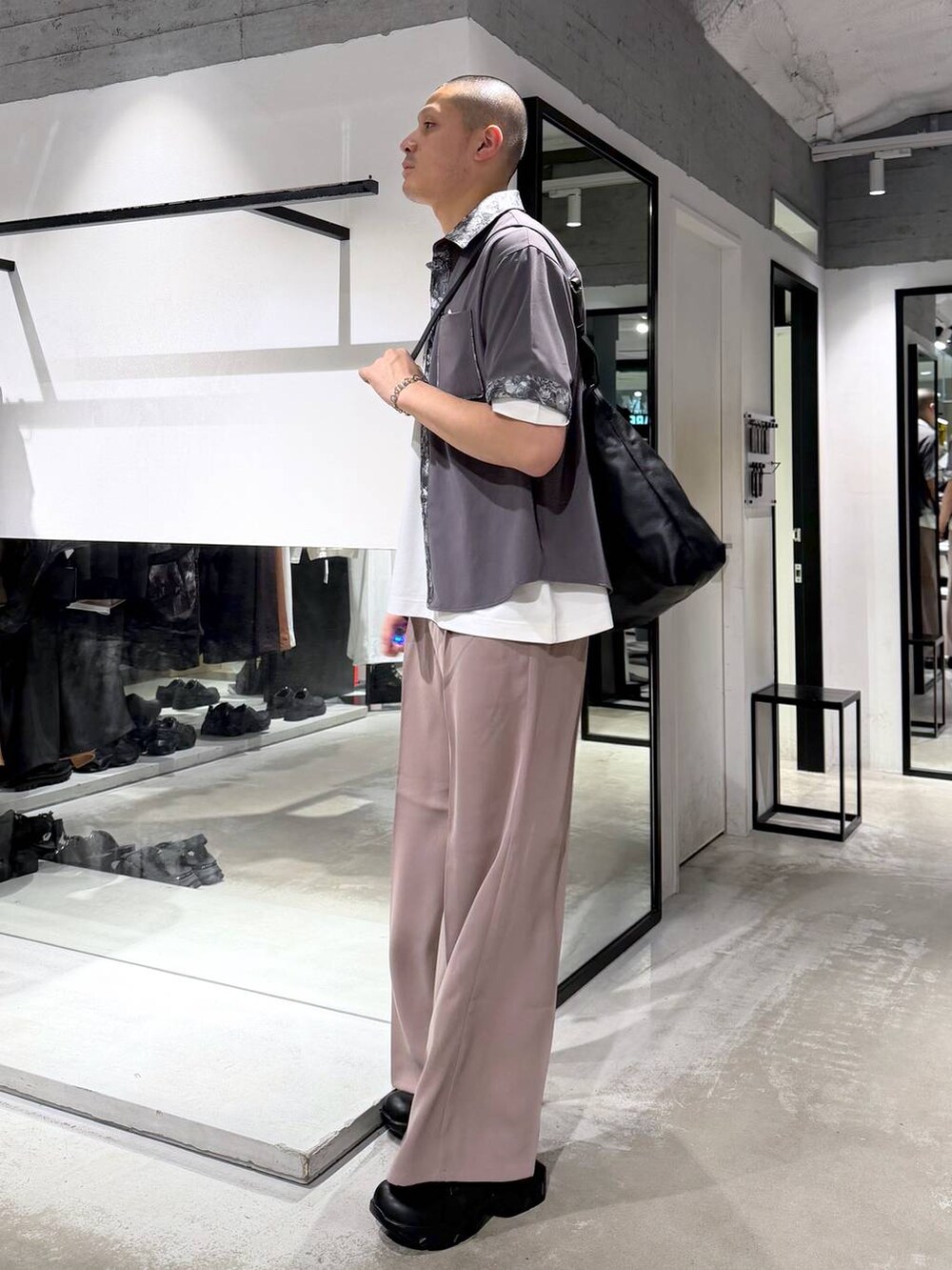 ピンク系のスラックス、ブラック系のドレスシューズ、ブラック系のトートバッグを着用したメンズの春コーディネートの4枚目の写真