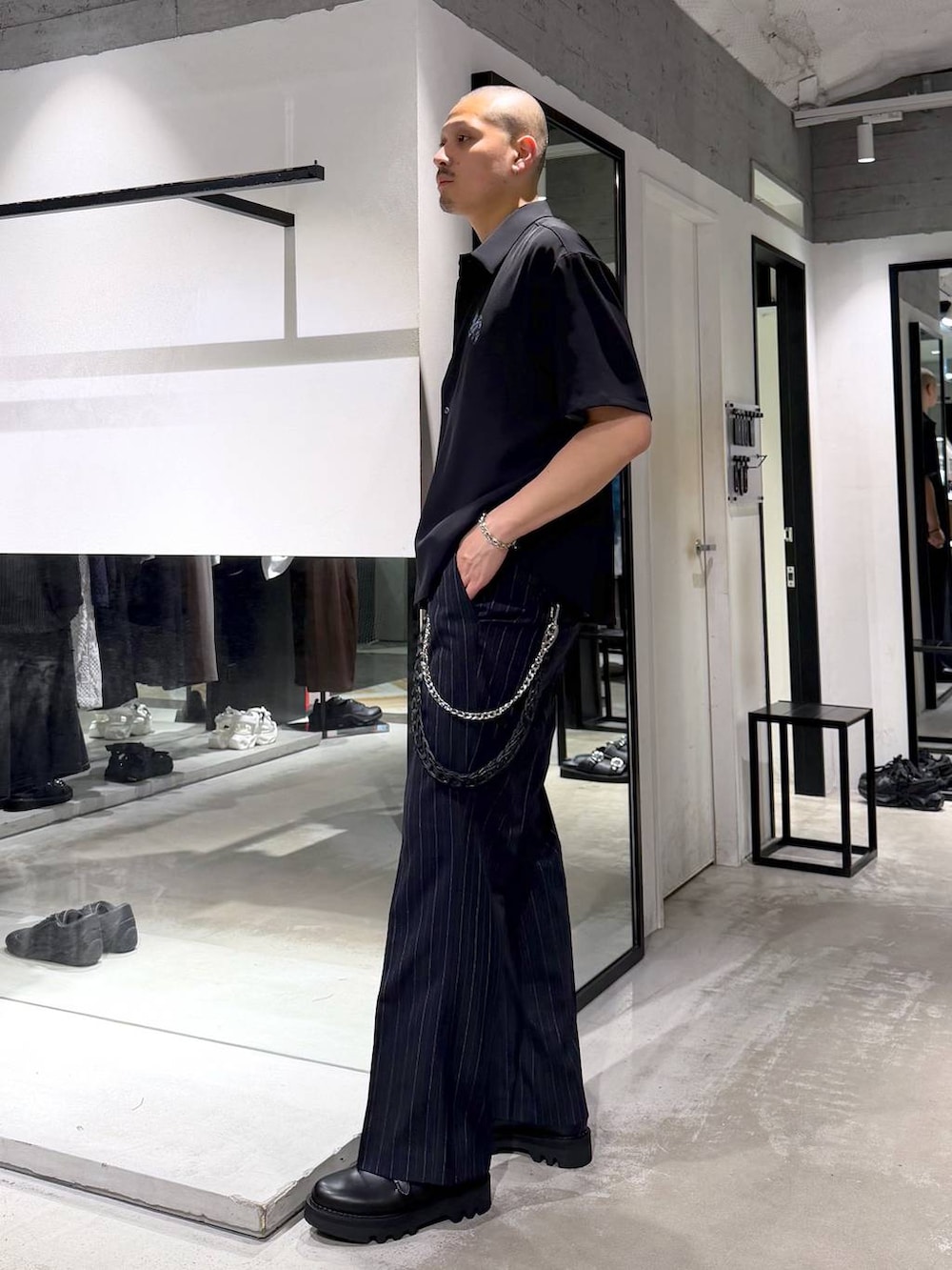 ブルー系のスラックス、ブラック系のドレスシューズ、ブルー系のTシャツ/カットソーを着用したメンズの夏コーディネートの2枚目の写真