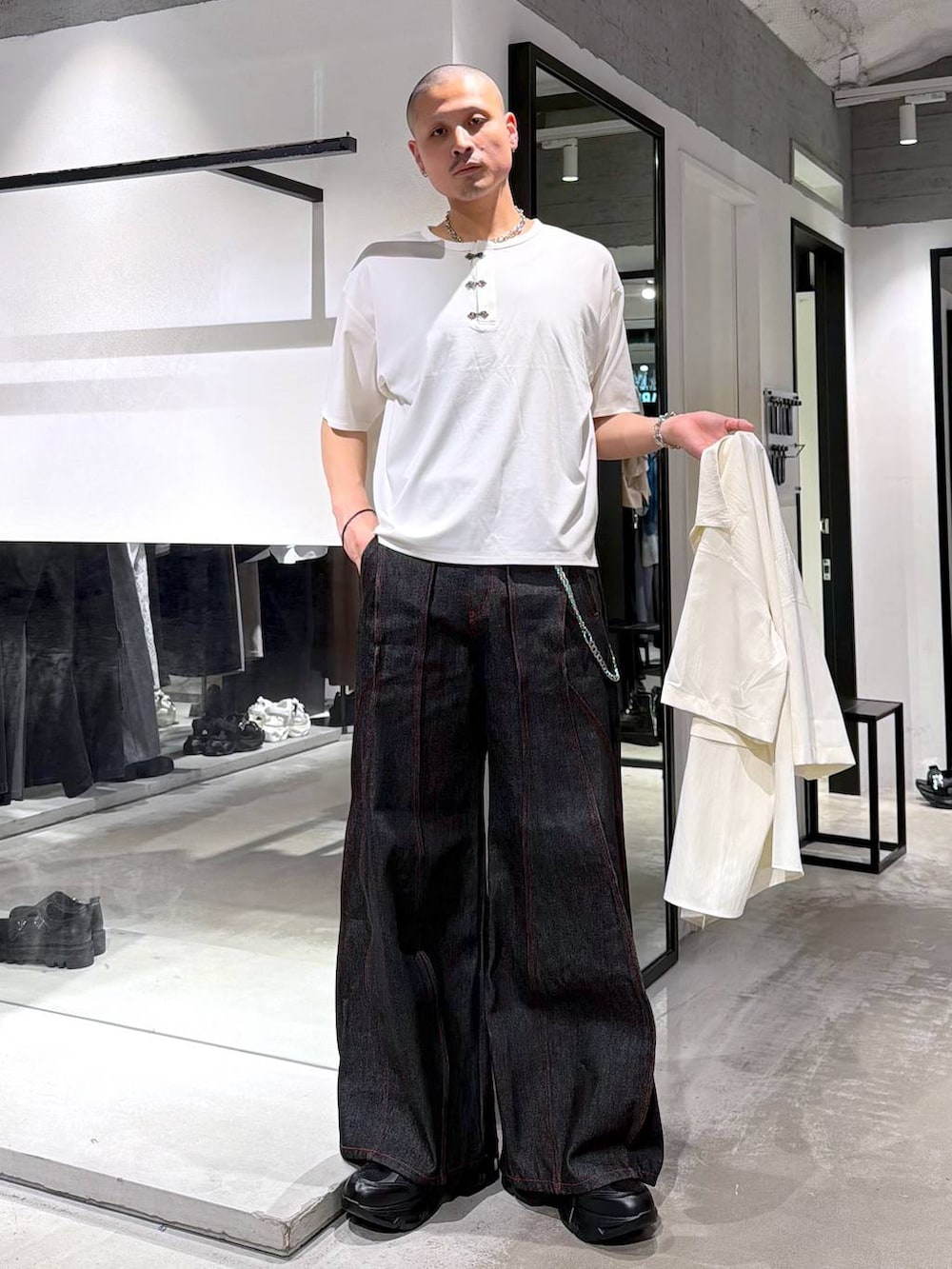 ブラック系のデニムパンツ、ブラック系のトートバッグ、ホワイト系のシャツ/ブラウスを着用したメンズの夏コーディネートの5枚目の写真