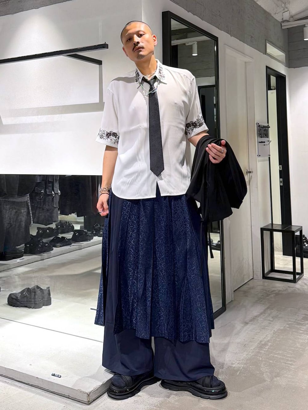 ホワイト系のシャツ/ブラウス、ブラック系のトートバッグ、ブラック系のネクタイを着用したメンズの夏コーディネートの6枚目の写真