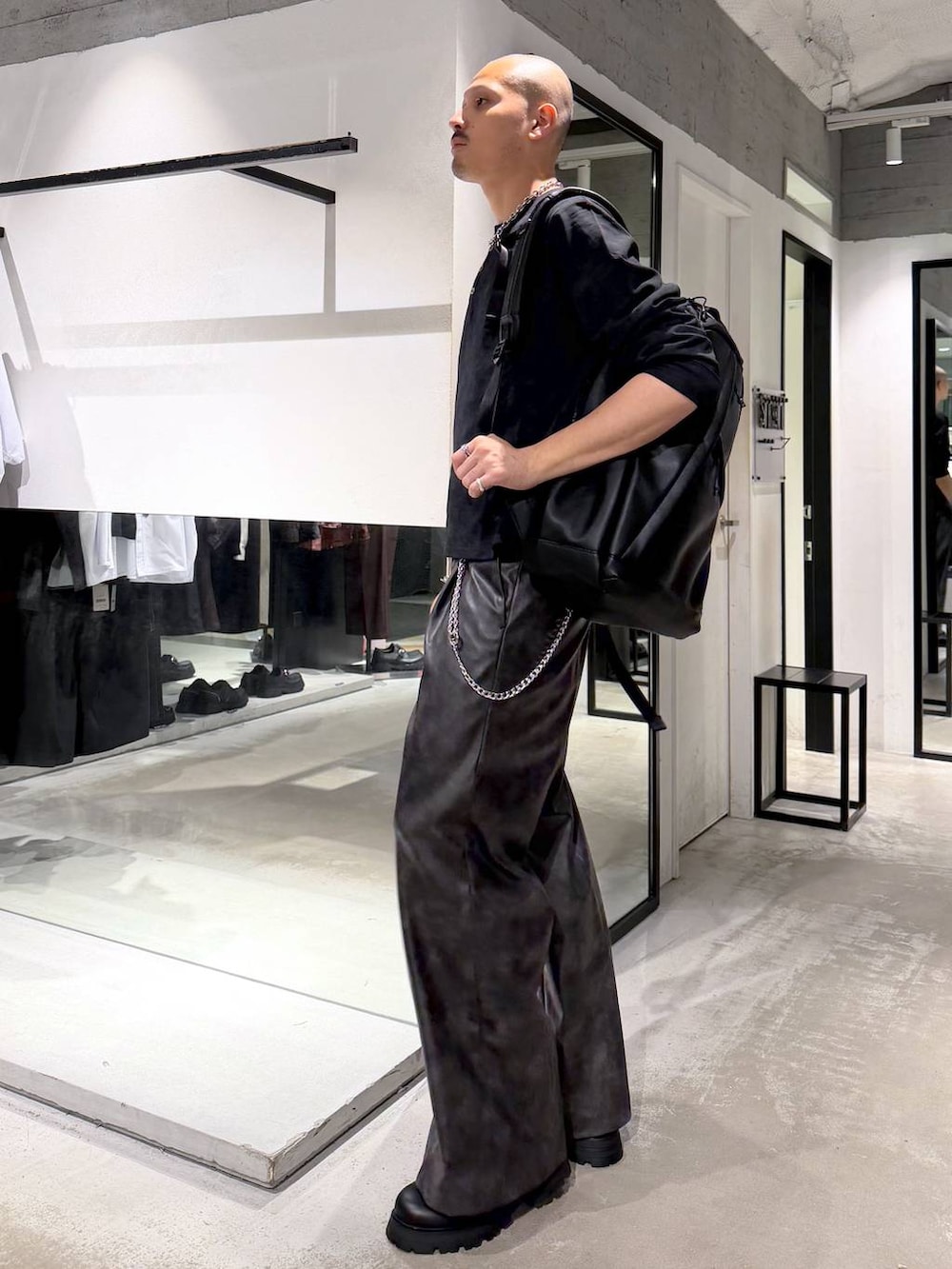 ブラック系のローファー、ブラック系のバックパック/リュック、ブラック系のTシャツ/カットソーを着用したメンズの秋コーディネートの2枚目の写真