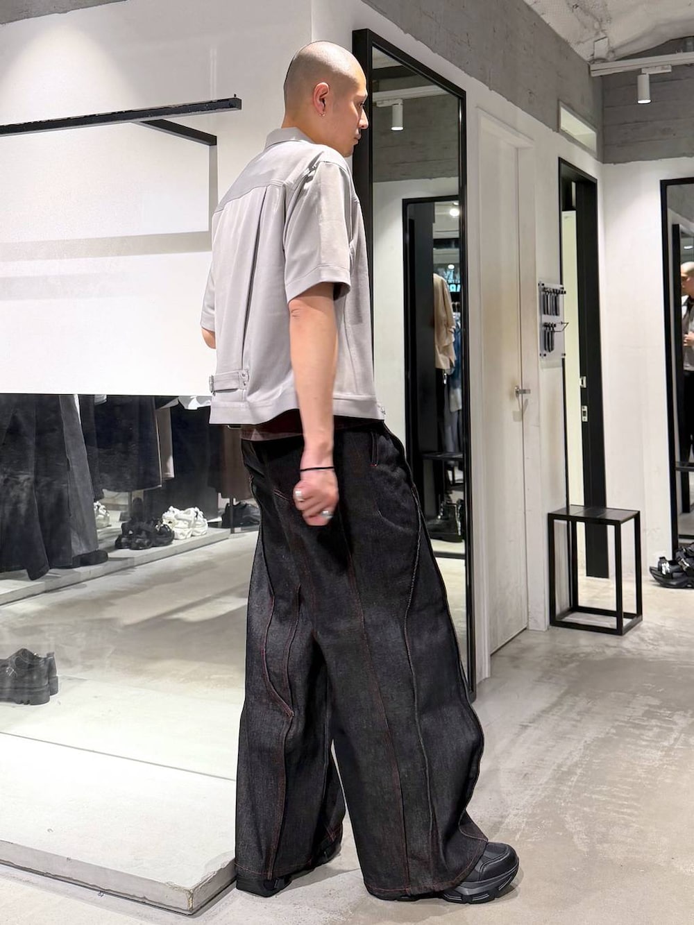 ブラック系のスニーカー、ブラック系のデニムパンツ、グレー系のシャツ/ブラウスを着用したメンズの春コーディネートの4枚目の写真