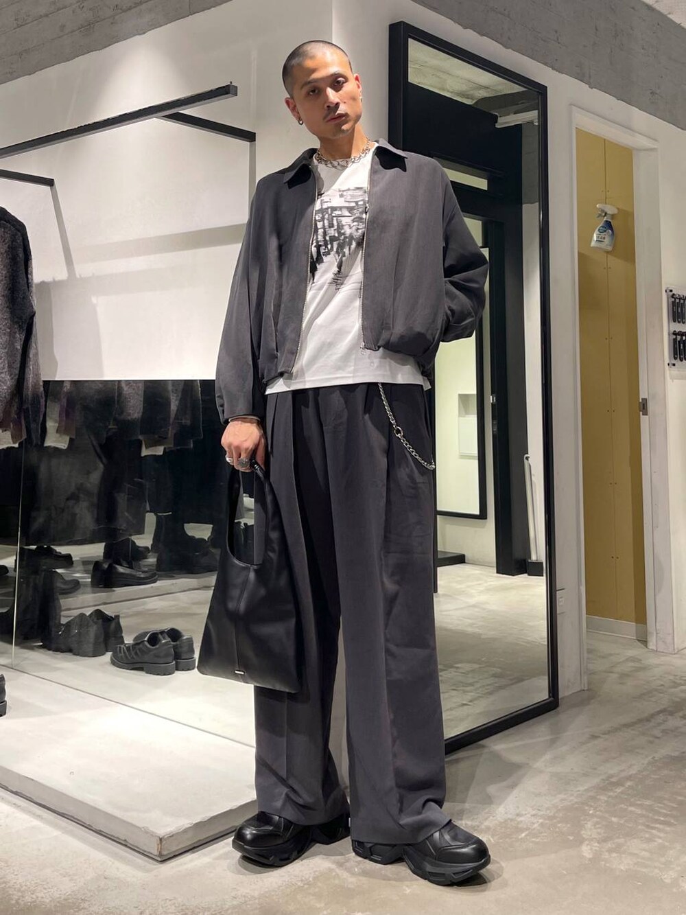 ブラック系のトートバッグ、ブラック系のスニーカー、ホワイト系のTシャツ/カットソーを着用したメンズの秋コーディネートの2枚目の写真