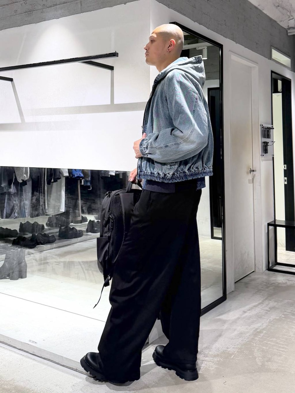 ブルー系のブルゾン、ブラック系のドレスシューズ、ブラック系のバックパック/リュックを着用したメンズの春コーディネートの3枚目の写真