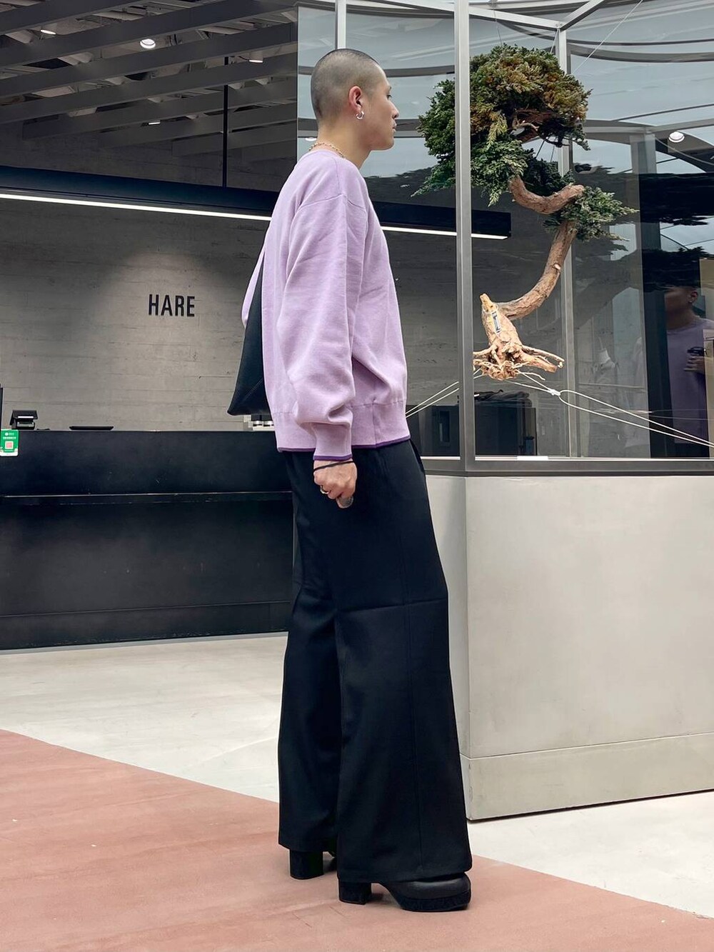 ブラック系のトートバッグ、ブラック系のブーツ、ブラック系のスラックスを着用したメンズの秋コーディネートの4枚目の写真