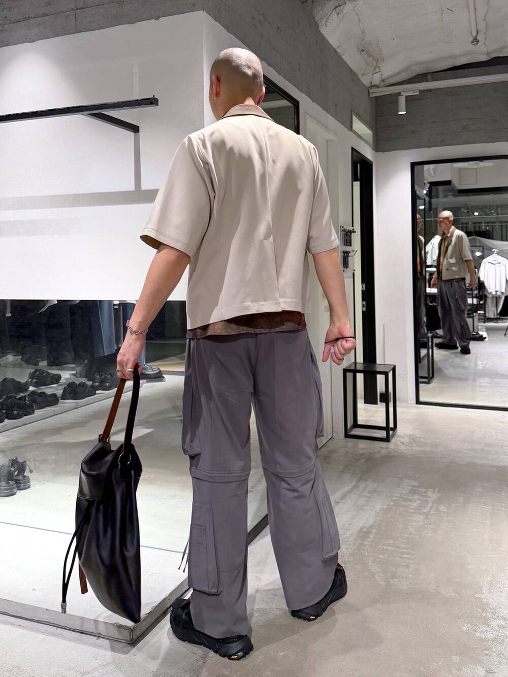 ブラック系のサンダル、グレー系のカーゴパンツ、ブラック系のトートバッグを着用したメンズの春コーディネートの3枚目の写真