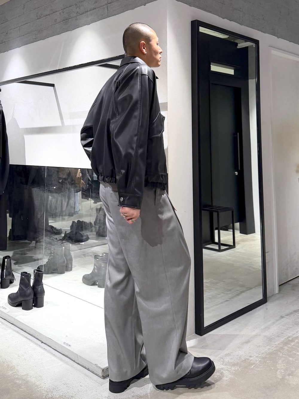 ブラック系のブルゾン、ブラック系のドレスシューズ、ブラック系のハンドバッグを着用したメンズの冬コーディネートの4枚目の写真