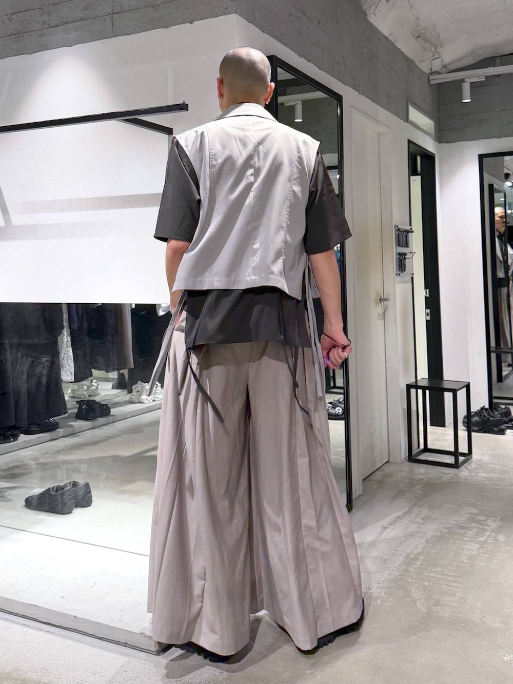 ブラック系のドレスシューズ、グレー系のベスト、ベージュ系のスラックスを着用したメンズの夏コーディネートの4枚目の写真