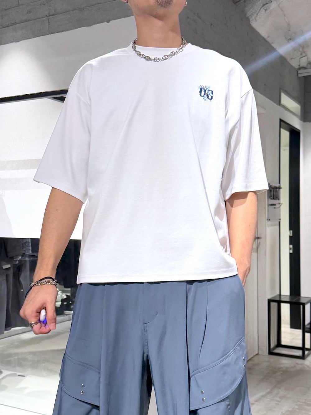 ホワイト系のTシャツ/カットソー、ブルー系のカーゴパンツ、ブラック系のサンダルを着用したメンズの夏コーディネートの5枚目の写真
