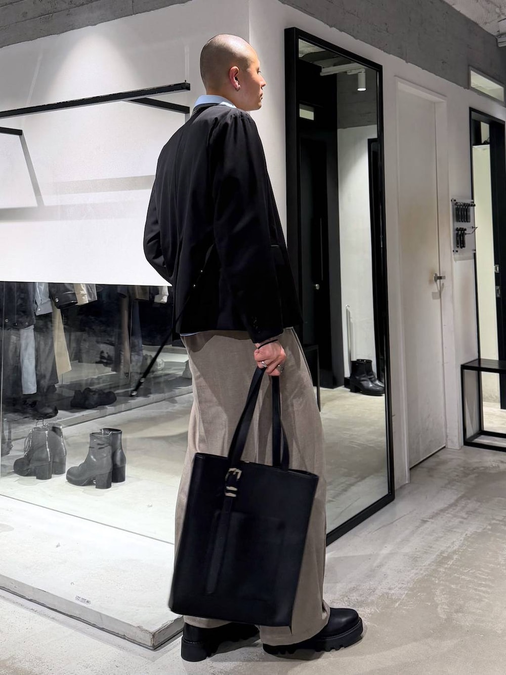 ブラック系のドレスシューズ、ブラック系のトートバッグ、ブラック系のテーラードジャケットを着用したメンズの冬コーディネートの4枚目の写真