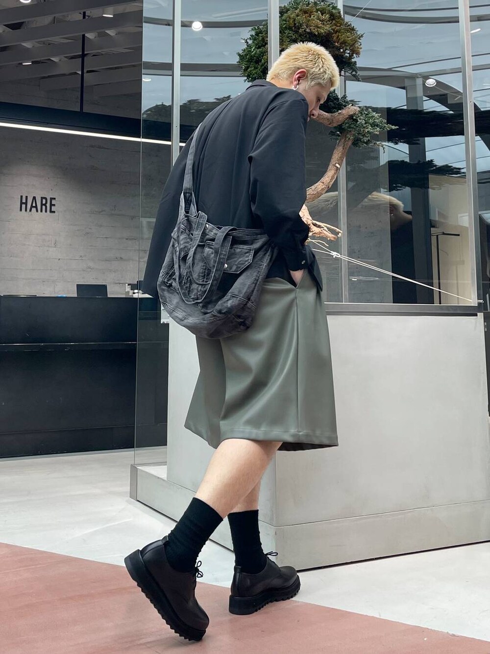 グリーン系のその他パンツ、ブラック系のショルダーバッグ、ブラック系のドレスシューズを着用したメンズの春コーディネートの2枚目の写真