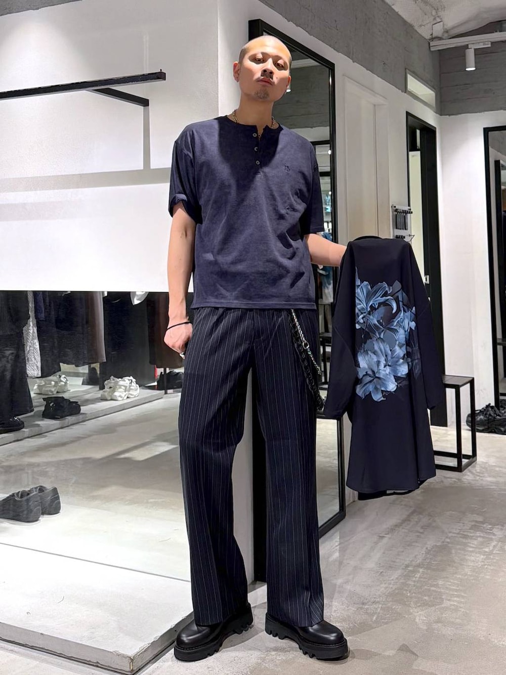 ブルー系のスラックス、ブラック系のドレスシューズ、ブルー系のTシャツ/カットソーを着用したメンズの夏コーディネートの5枚目の写真
