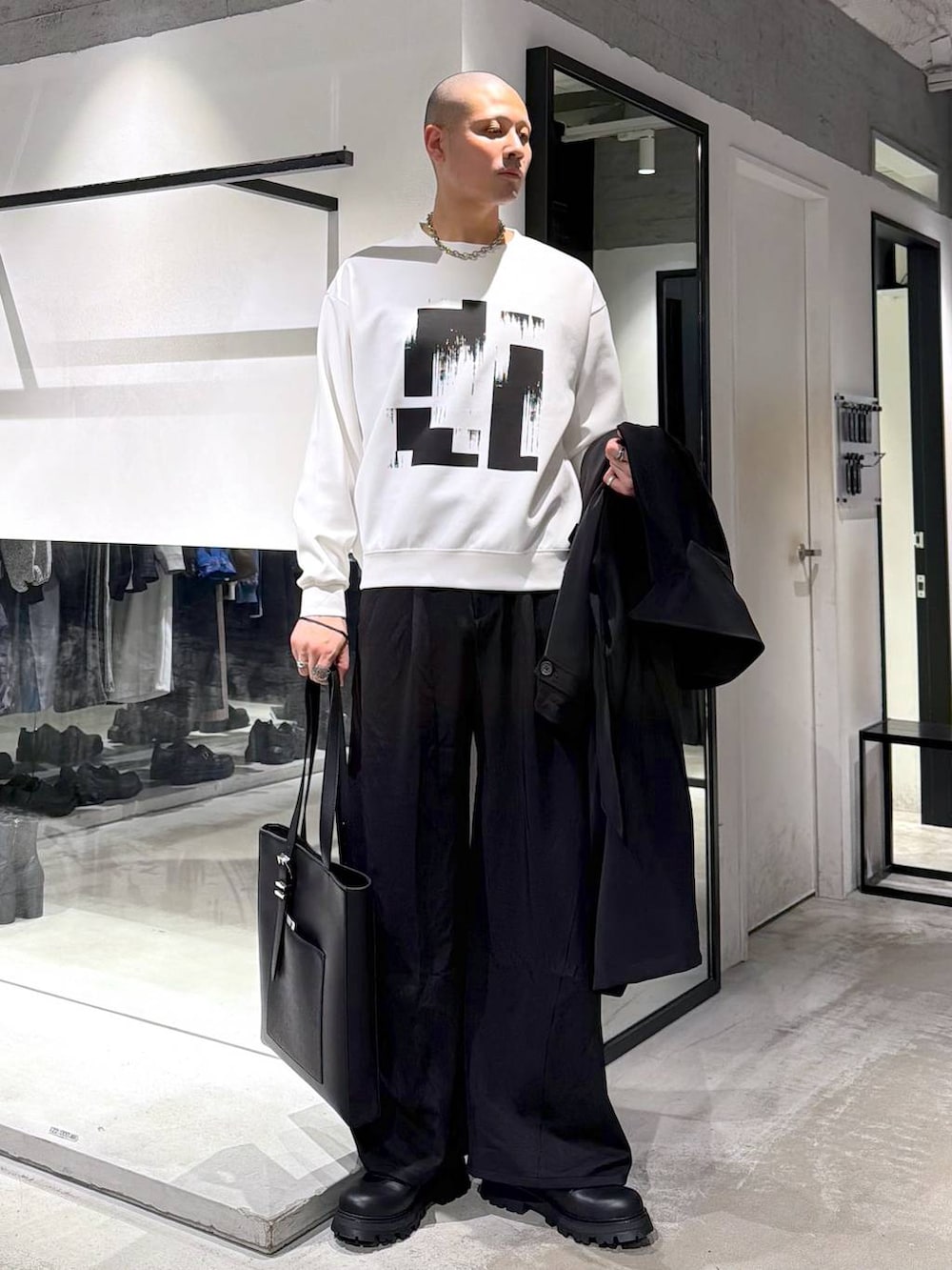 ブラック系のトートバッグ、ブラック系のドレスシューズ、ブラック系のトレンチコートを着用したメンズの春コーディネートの5枚目の写真