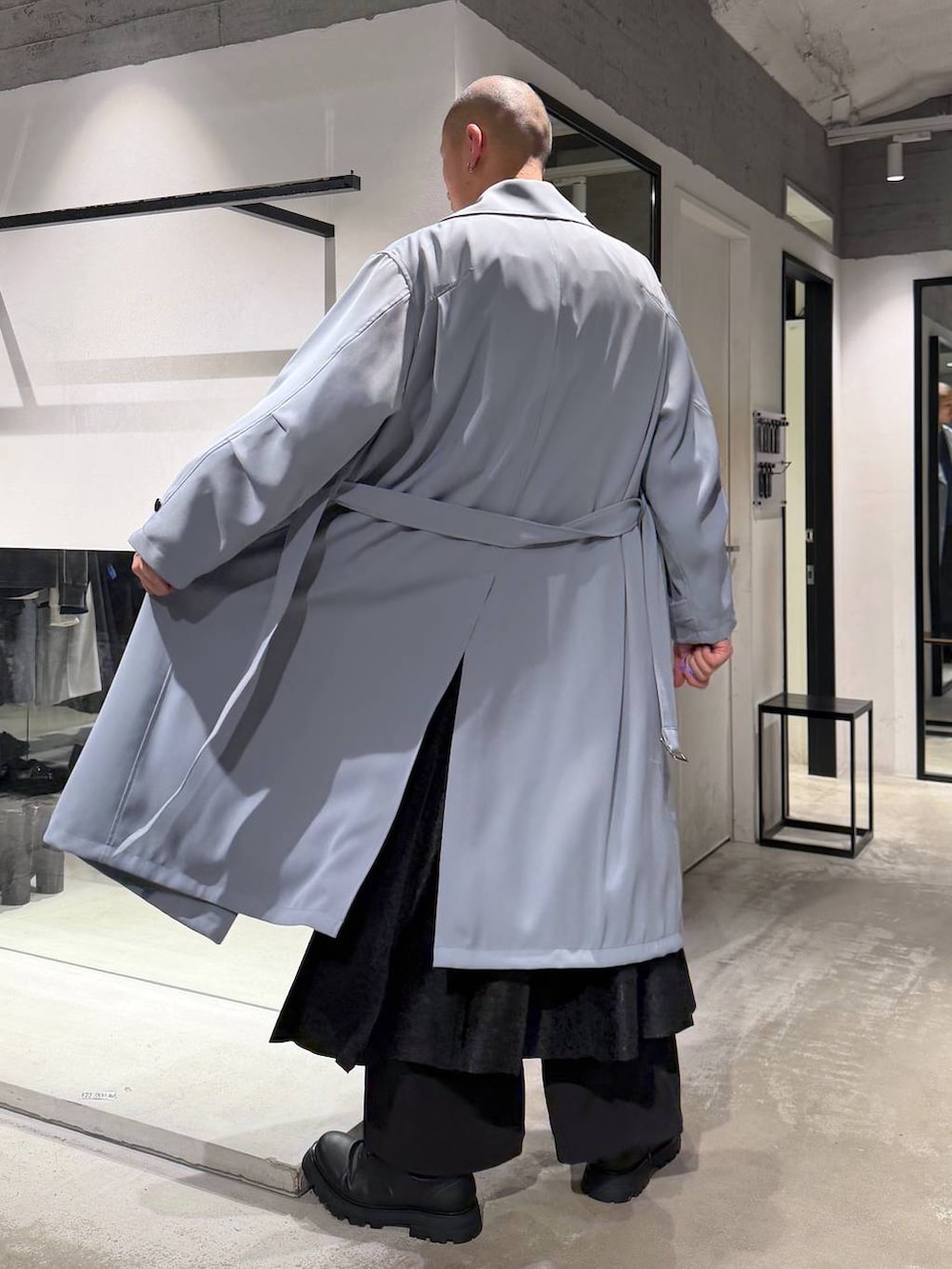 ブラック系のその他パンツ、ブラック系のドレスシューズ、グリーン系のトレンチコートを着用したメンズの春コーディネートの3枚目の写真