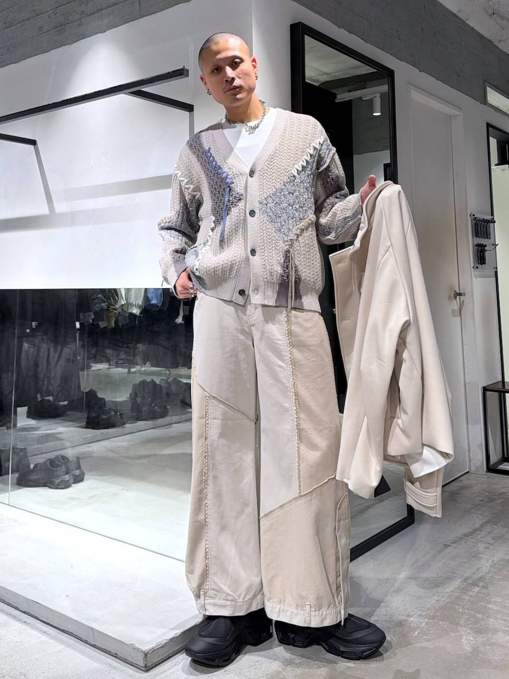 グレー系のカーディガン/ボレロ、ブラック系のブーツ、ホワイト系のブルゾンを着用したメンズの冬コーディネートの5枚目の写真