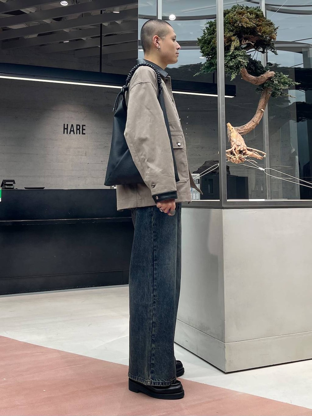 ホワイト系のTシャツ/カットソー、ブラック系のローファー、ブルー系のデニムパンツを着用したメンズの秋コーディネートの4枚目の写真