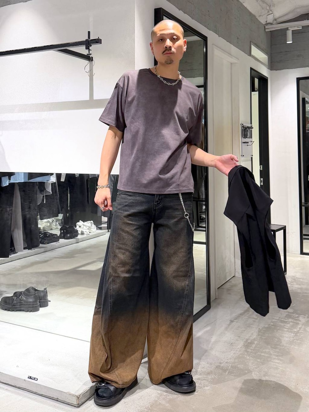 オレンジ系のデニムパンツ、ブラック系のサンダル、ブラック系のショルダーバッグを着用したメンズの夏コーディネートの6枚目の写真