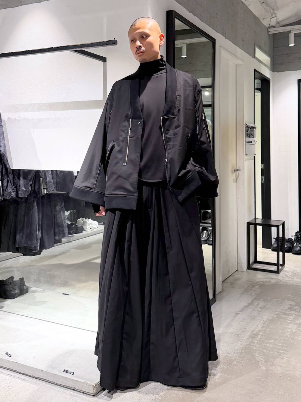 ブラック系のブルゾン、ブラック系のTシャツ/カットソー、ブラック系のブーツを着用したメンズの秋コーディネートの5枚目の写真