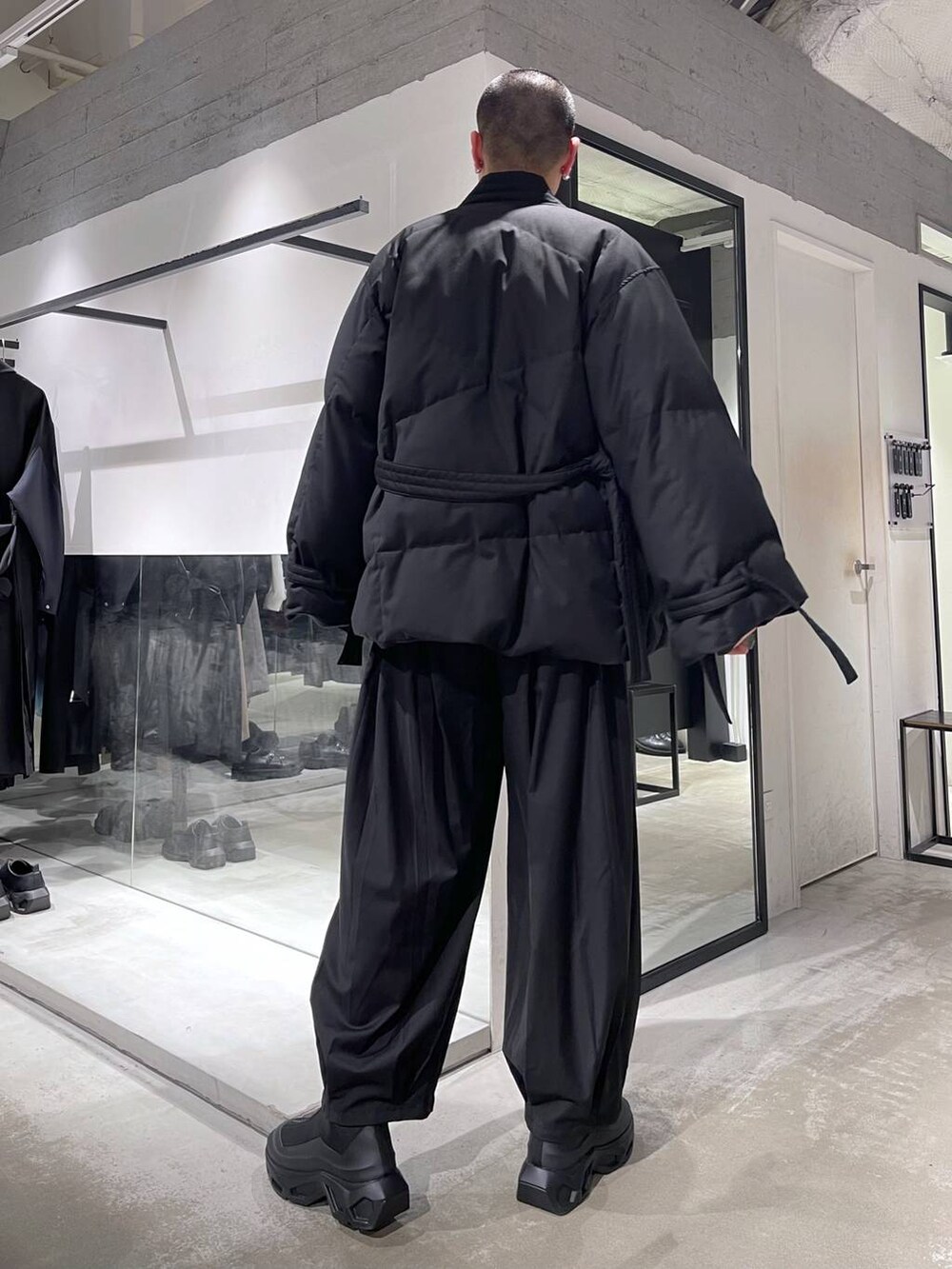 グレー系のカーディガン/ボレロ、ブラック系のダウンジャケット/コート、ブラック系のブーツを着用したメンズの冬コーディネートの3枚目の写真