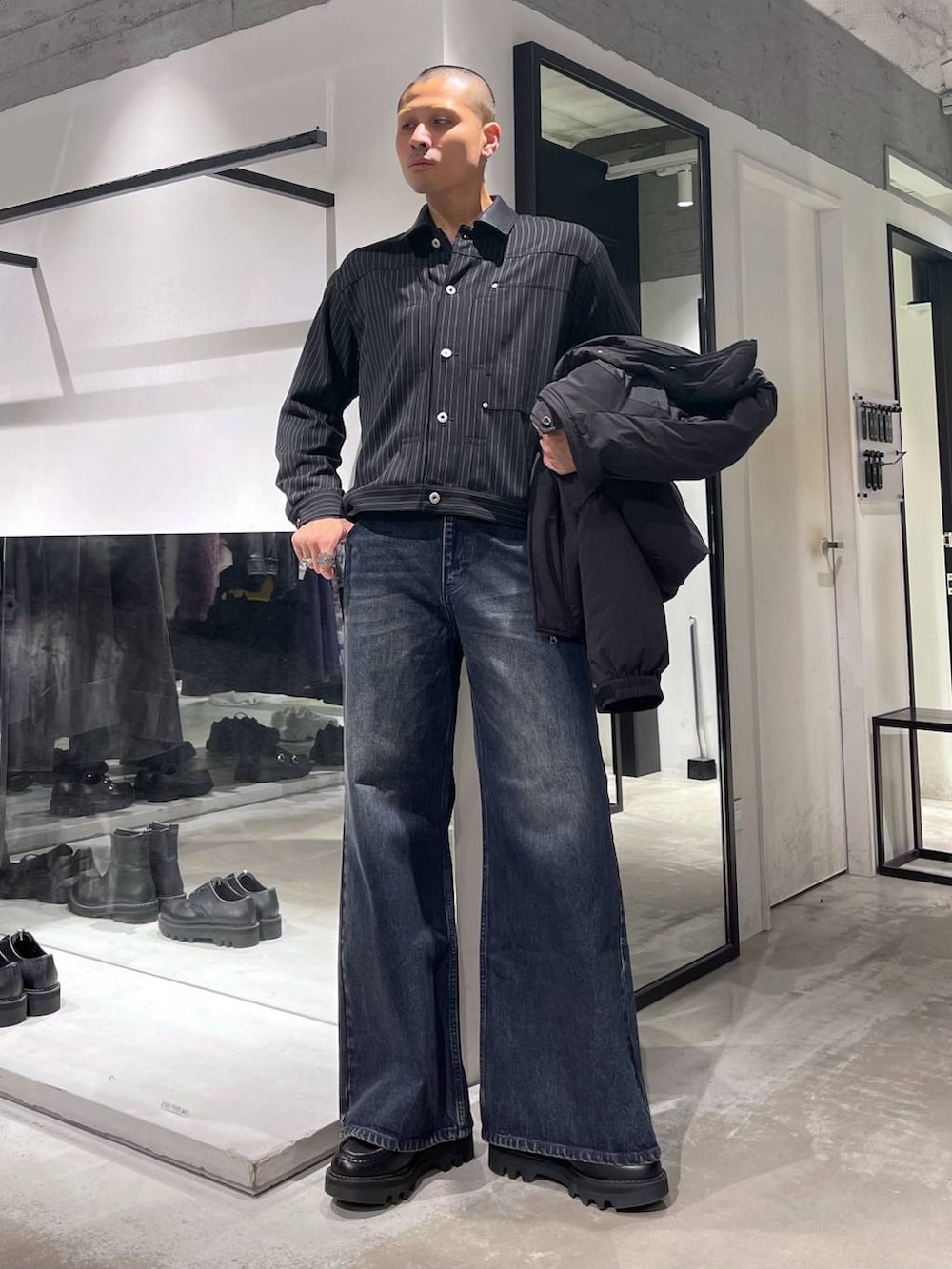 ブラック系のダウンジャケット/コート、ブルー系のデニムパンツ、ブラック系のブルゾンを着用したメンズの秋コーディネートの5枚目の写真