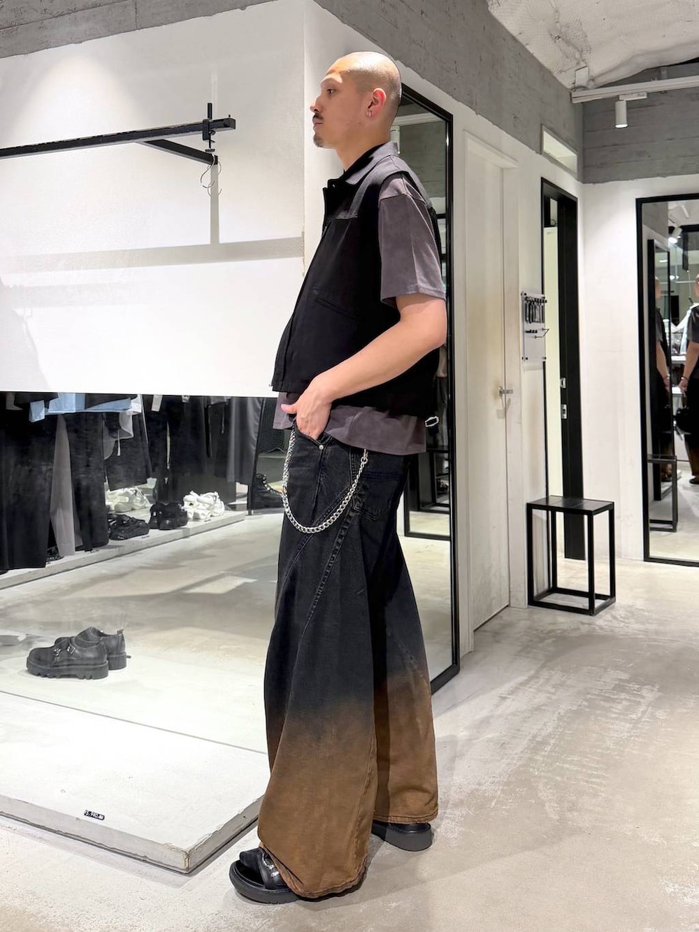 オレンジ系のデニムパンツ、ブラック系のサンダル、ブラック系のショルダーバッグを着用したメンズの夏コーディネートの2枚目の写真