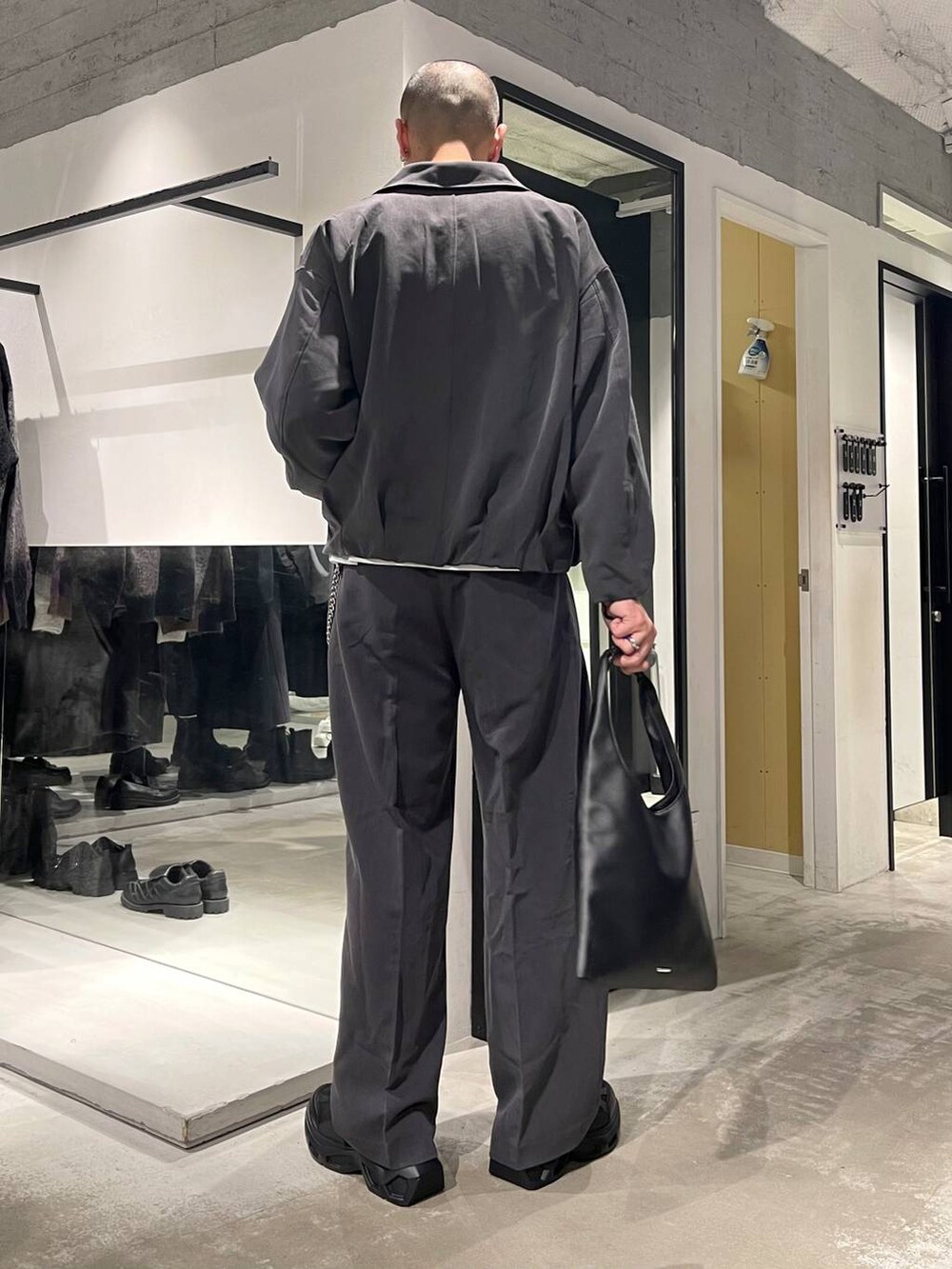 ブラック系のトートバッグ、ブラック系のスニーカー、ホワイト系のTシャツ/カットソーを着用したメンズの秋コーディネートの4枚目の写真