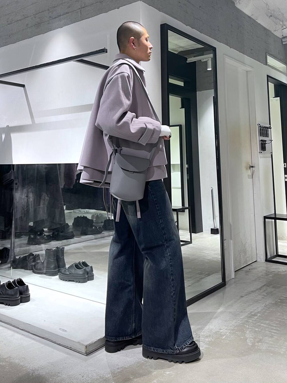 パープル系のブルゾン、ブルー系のデニムパンツ、ブラック系のドレスシューズを着用したメンズの秋コーディネートの4枚目の写真