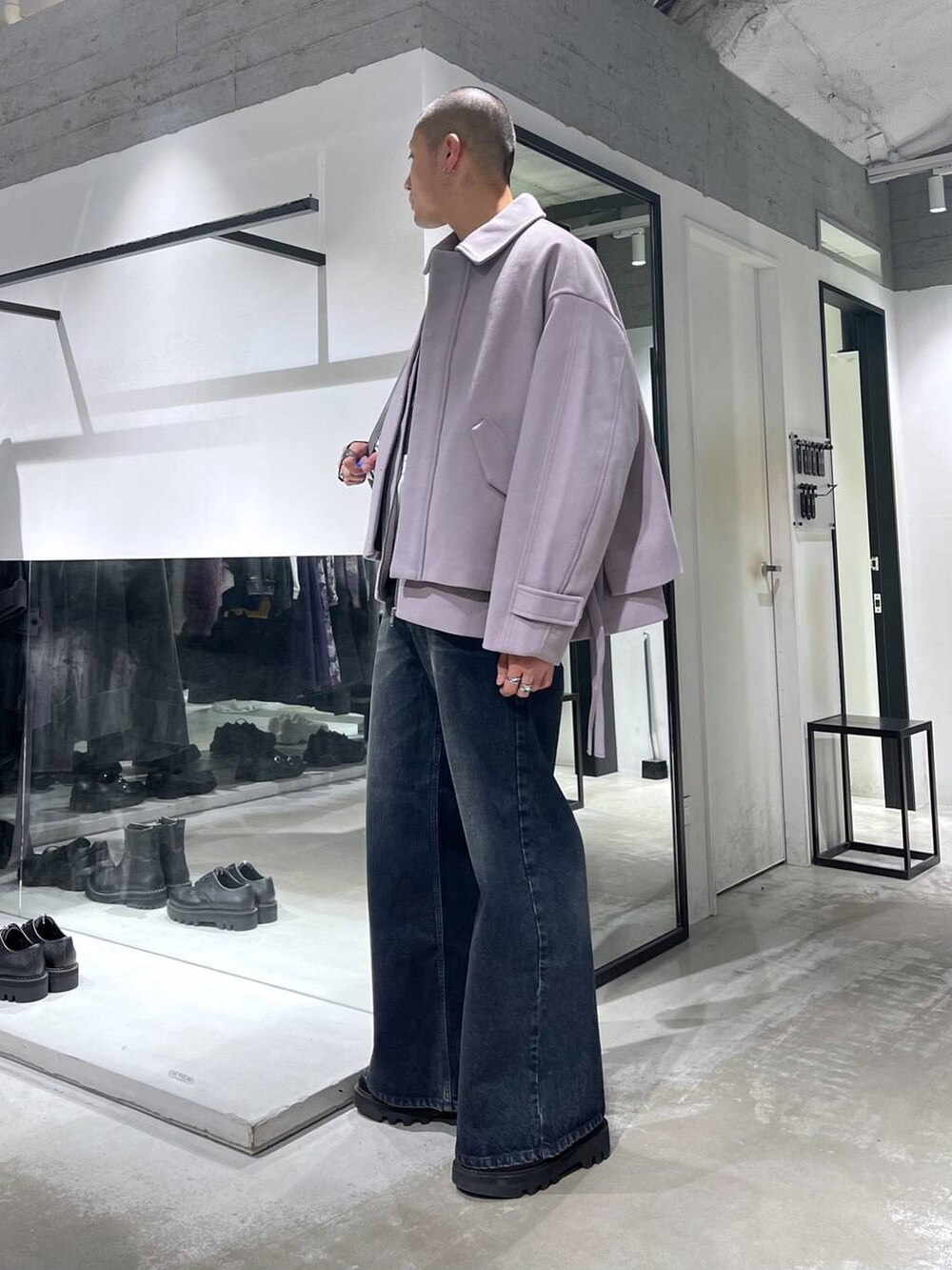 パープル系のブルゾン、ブルー系のデニムパンツ、ブラック系のドレスシューズを着用したメンズの秋コーディネートの2枚目の写真