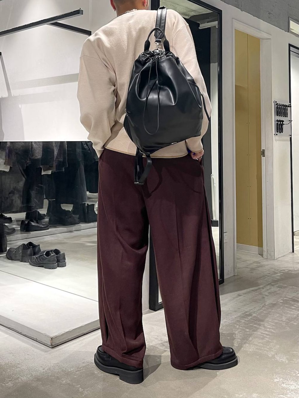 ブラック系のローファー、ブラック系のバックパック/リュック、ホワイト系のニット/セーターを着用したメンズの秋コーディネートの3枚目の写真