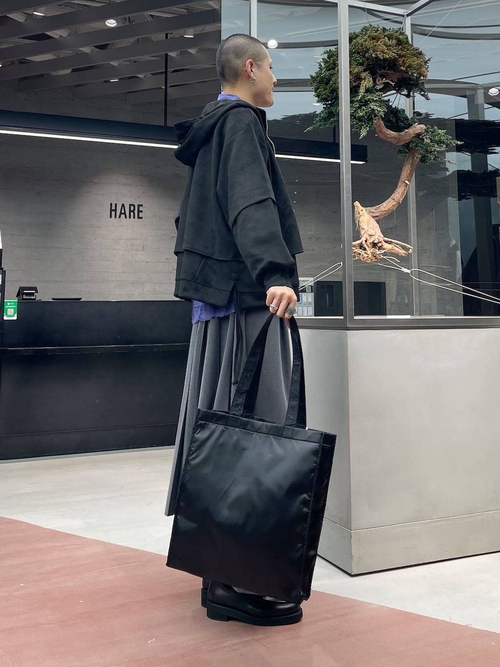 ブラック系のトートバッグ、グレー系のその他パンツ、ブラック系のローファーを着用したメンズの秋コーディネートの4枚目の写真