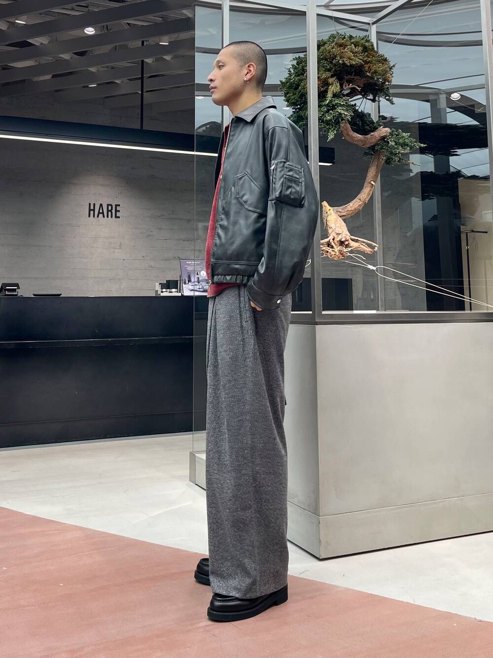 グレー系のブルゾン、ブラック系のローファー、ブラック系のスラックスを着用したメンズの秋コーディネートの2枚目の写真