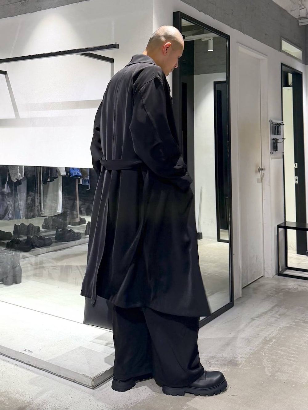 ブラック系のトートバッグ、ブラック系のドレスシューズ、ブラック系のトレンチコートを着用したメンズの春コーディネートの4枚目の写真