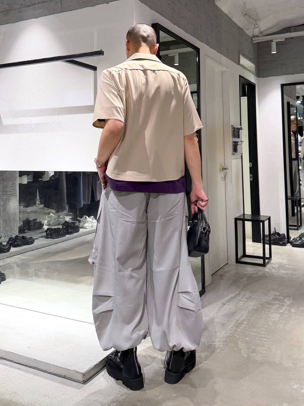 パープル系のTシャツ/カットソー、グレー系のカーゴパンツ、ブラック系のショルダーバッグを着用したメンズの春コーディネートの3枚目の写真