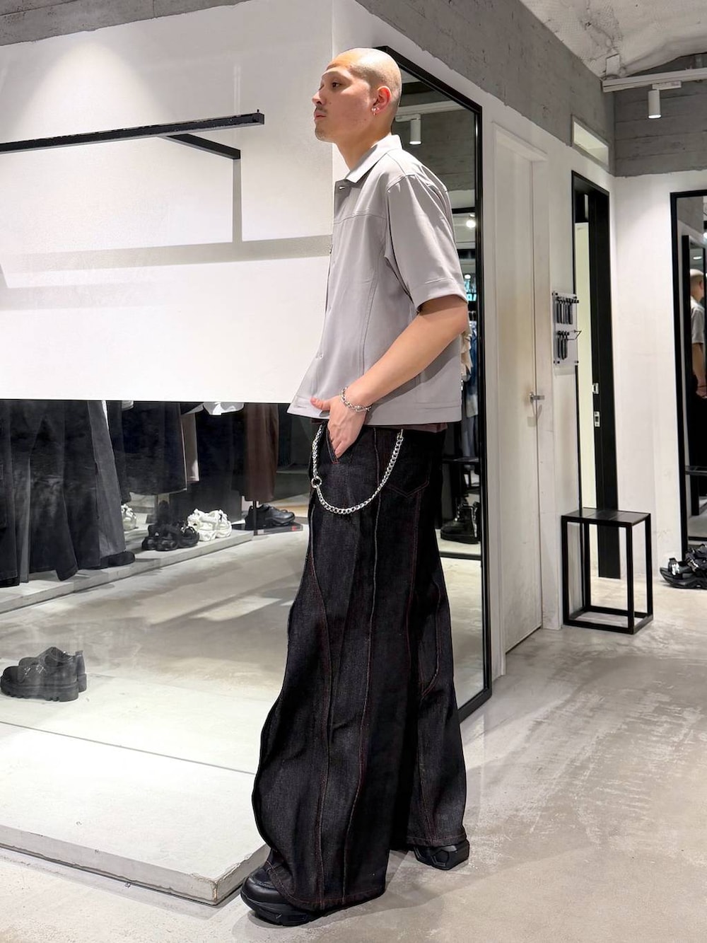 ブラック系のスニーカー、ブラック系のデニムパンツ、グレー系のシャツ/ブラウスを着用したメンズの春コーディネートの2枚目の写真