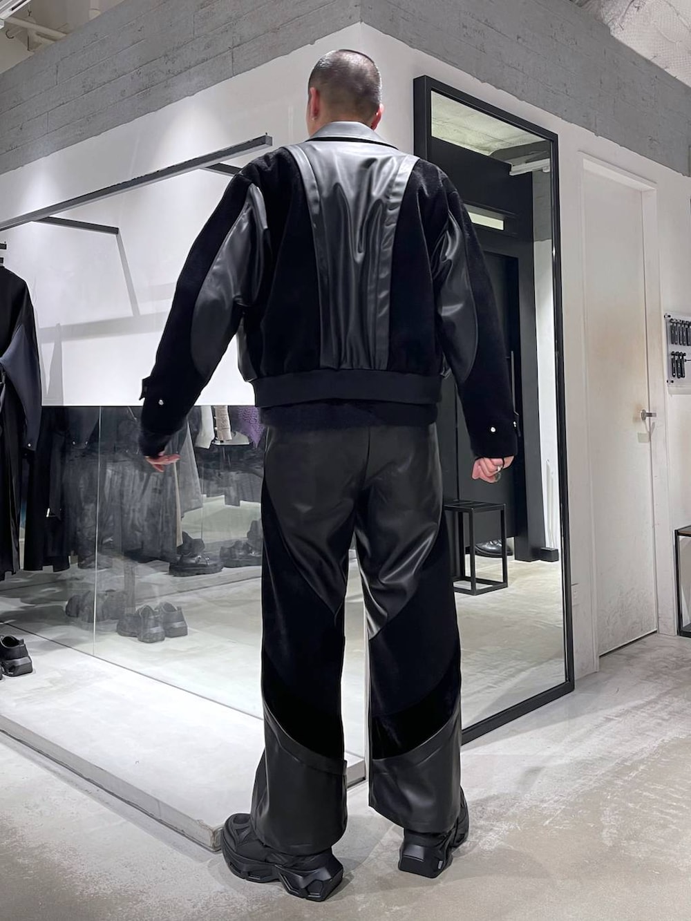 ブラック系のスニーカー、ブラック系のショルダーバッグ、ブラック系のブルゾンを着用したメンズの冬コーディネートの3枚目の写真