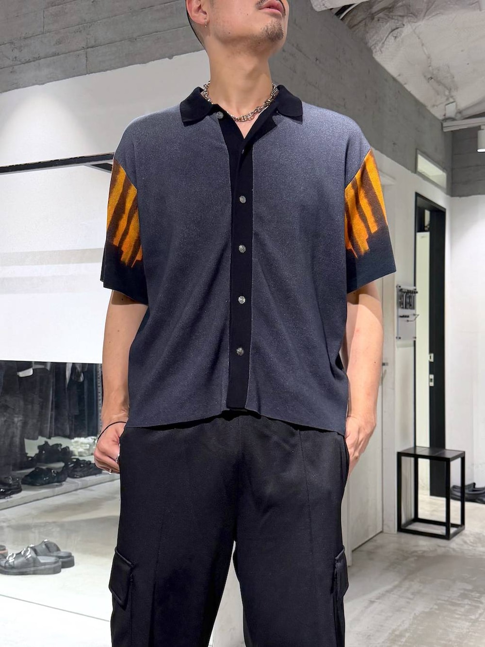 ブラック系のカーゴパンツ、ブラック系のニット/セーター、ブラック系のサンダルを着用したメンズの夏コーディネートの4枚目の写真