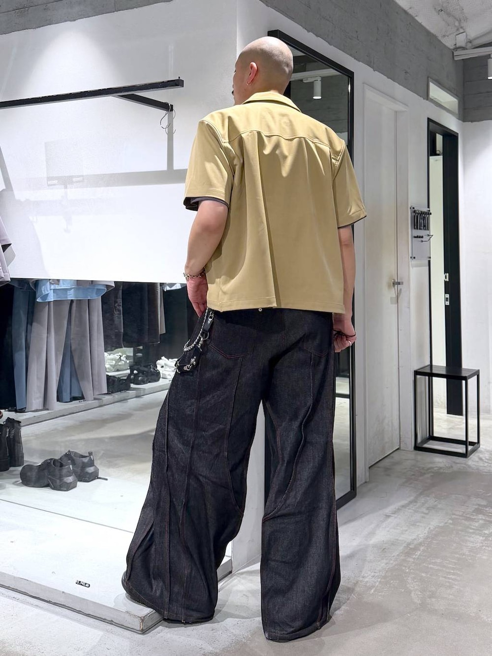 ブラック系のデニムパンツ、ブラック系のサンダル、グレー系のTシャツ/カットソーを着用したメンズの夏コーディネートの3枚目の写真
