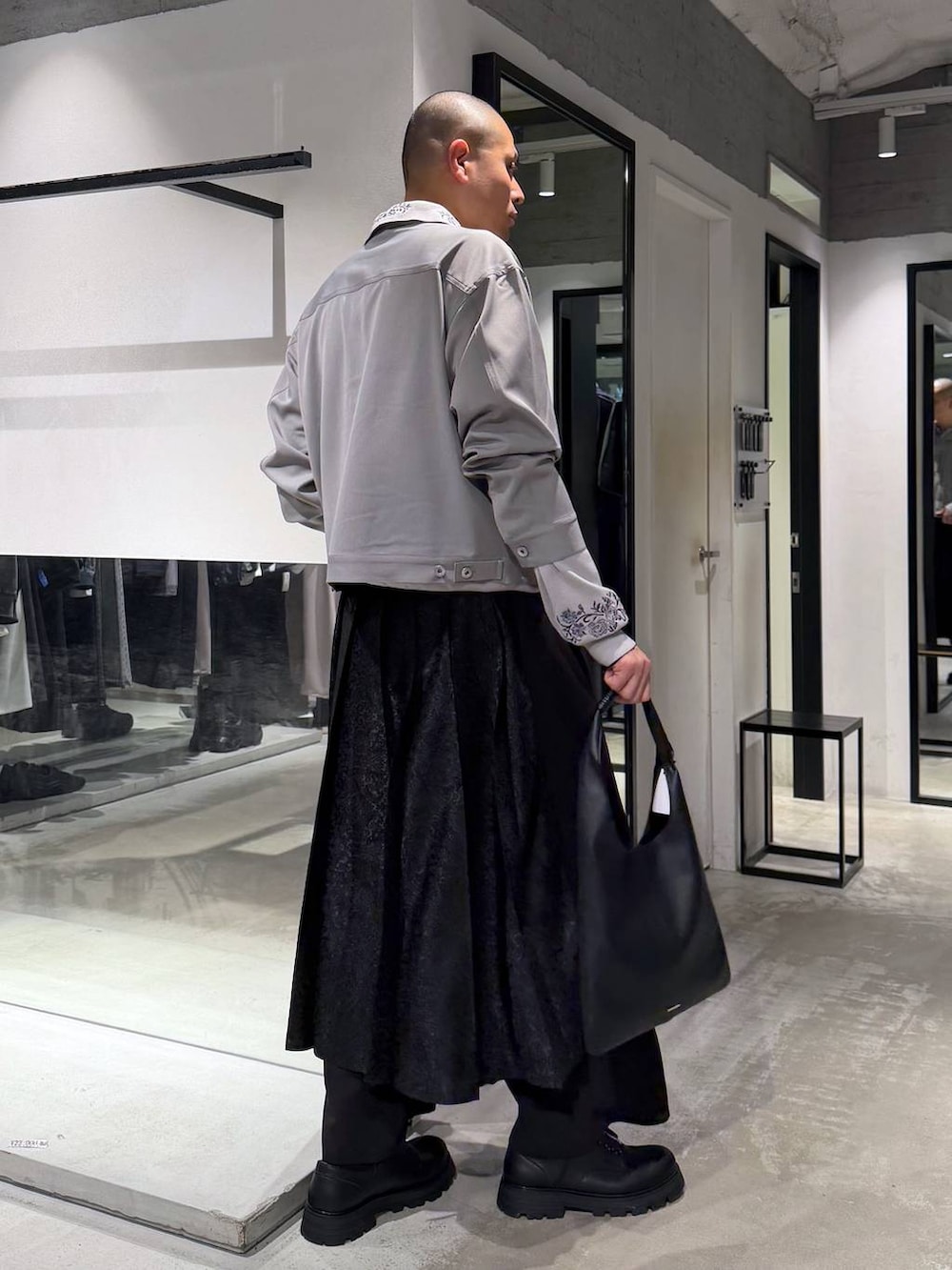 ブラック系のトートバッグ、グレー系のポロシャツ、ブラック系のその他パンツを着用したメンズの春コーディネートの5枚目の写真