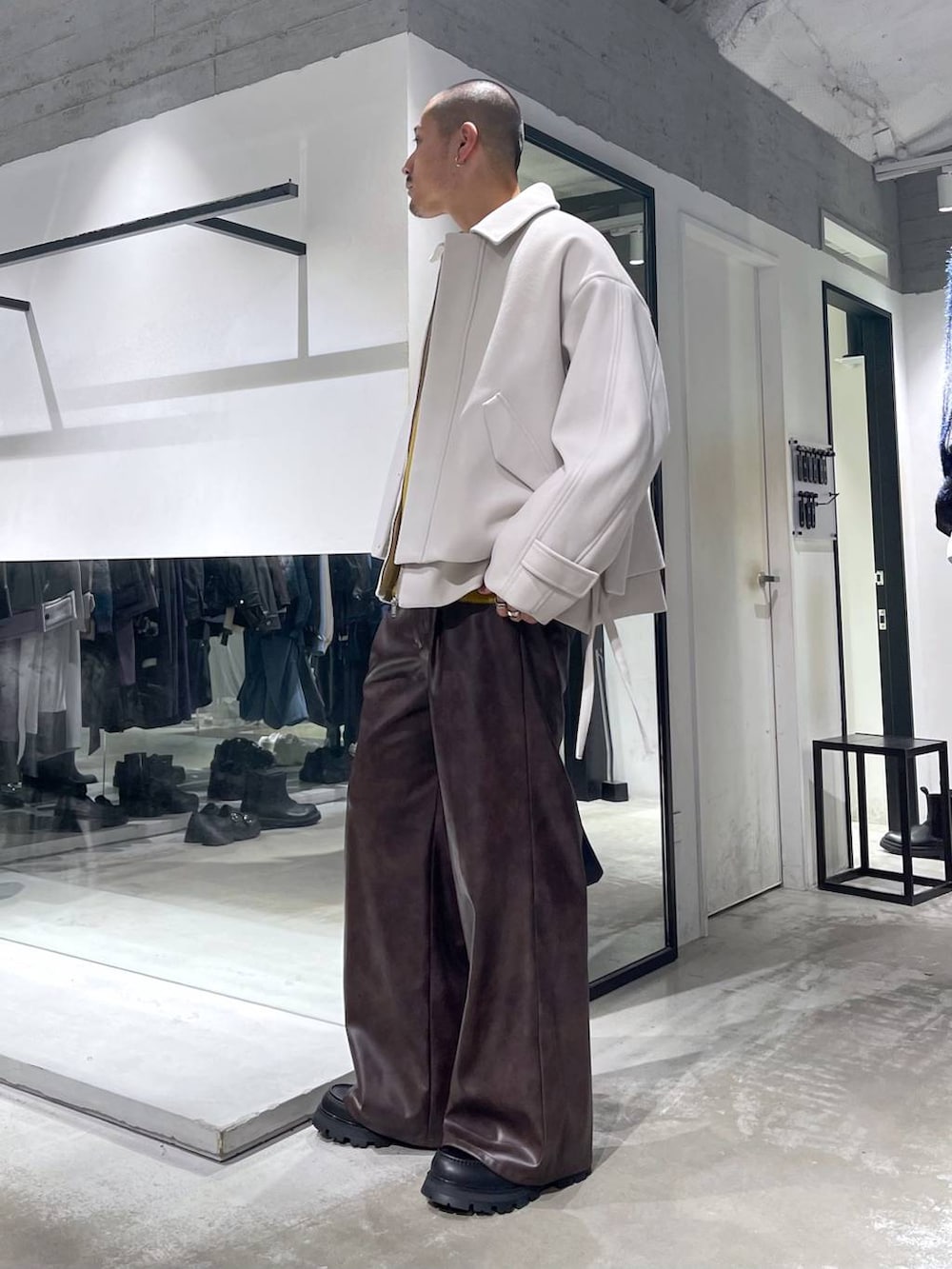 ブラック系のトートバッグ、ホワイト系のブルゾン、イエロー系のニット/セーターを着用したメンズの秋コーディネートの2枚目の写真