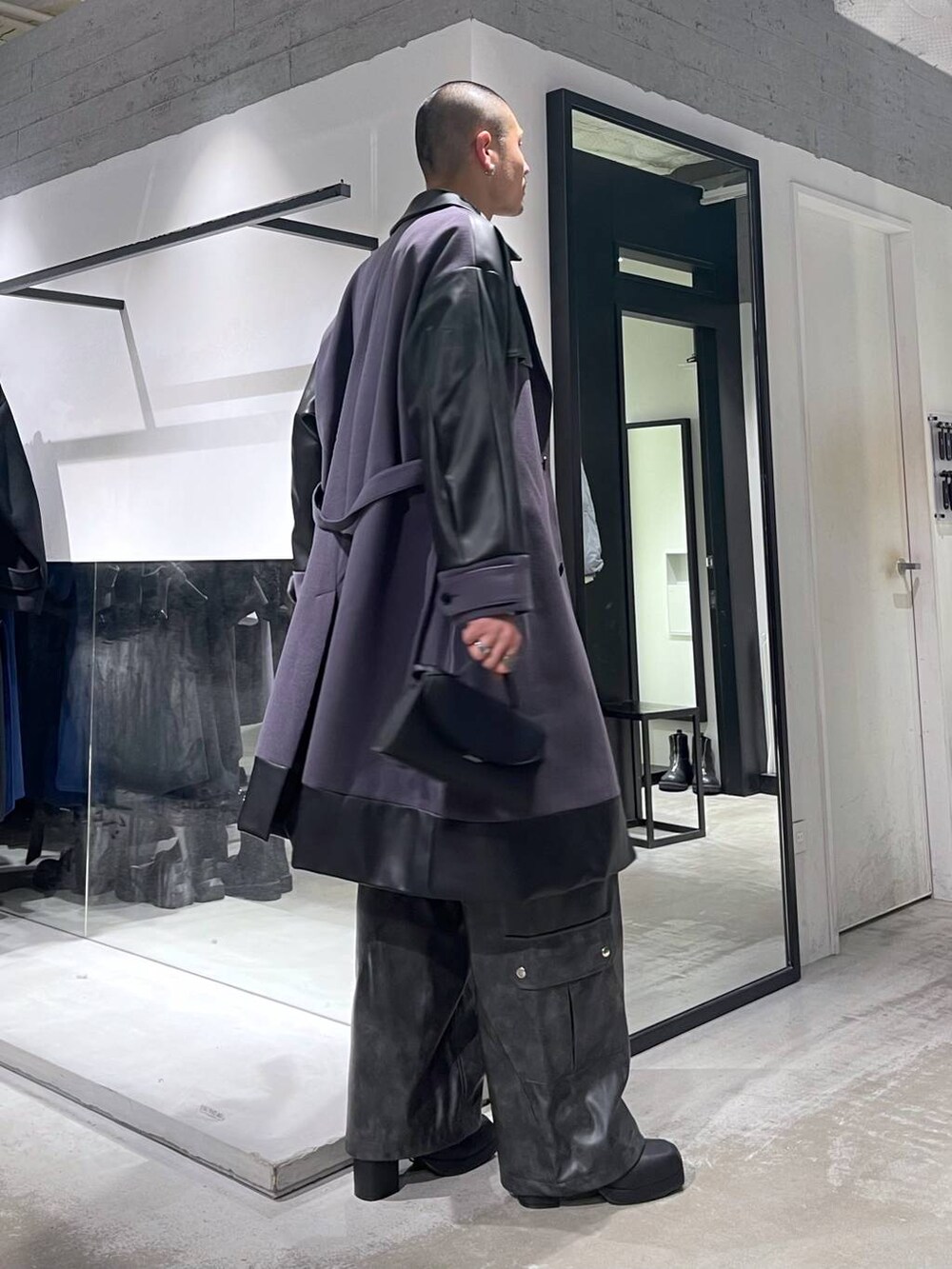 パープル系のトレンチコート、グレー系のカーゴパンツ、ブラック系のブーツを着用したメンズの冬コーディネートの4枚目の写真