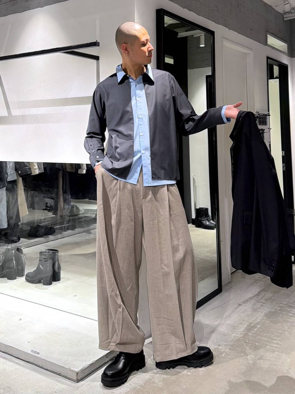 ブラック系のドレスシューズ、ブラック系のトートバッグ、ブラック系のテーラードジャケットを着用したメンズの冬コーディネートの5枚目の写真