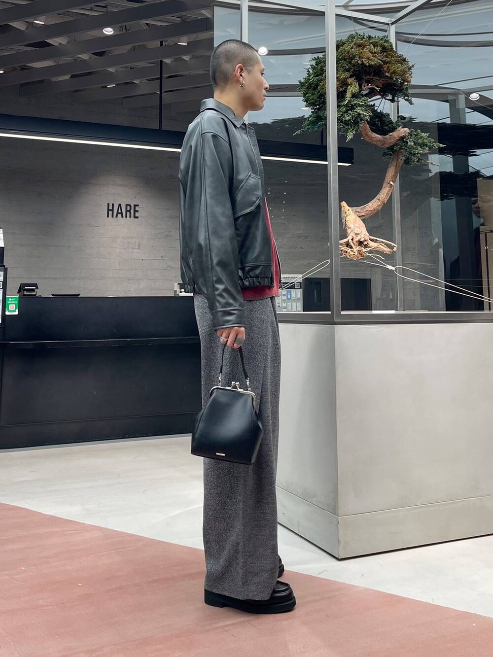 グレー系のブルゾン、ブラック系のローファー、ブラック系のスラックスを着用したメンズの秋コーディネートの4枚目の写真