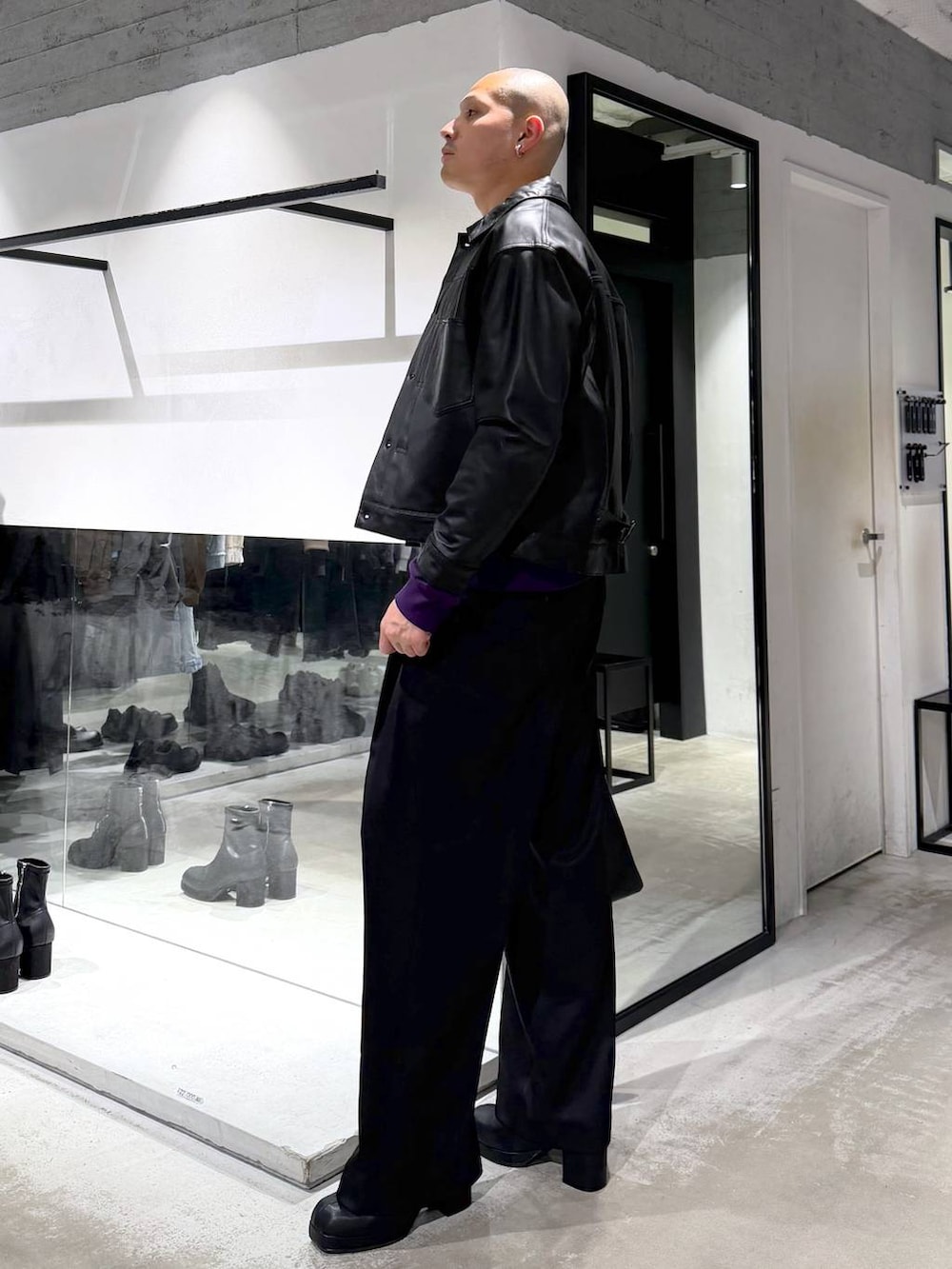 ブラック系のトートバッグ、ブラック系のブーツ、パープル系のスウェットを着用したメンズの冬コーディネートの3枚目の写真
