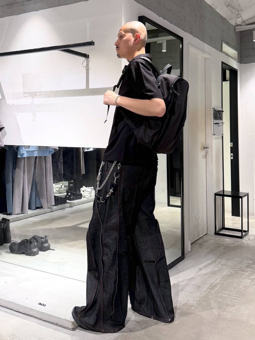 ブラック系のデニムパンツ、パープル系のTシャツ/カットソー、ブラック系のバックパック/リュックを着用したメンズの夏コーディネートの3枚目の写真