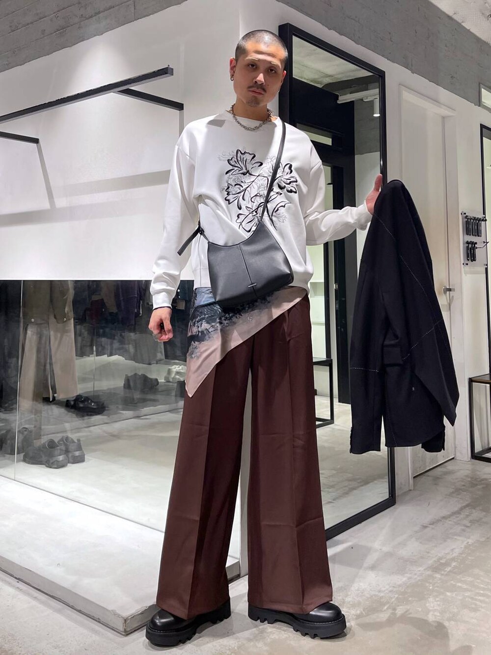 レッド系のスラックス、ブラック系のショルダーバッグ、ブラック系のドレスシューズを着用したメンズの冬コーディネートの5枚目の写真