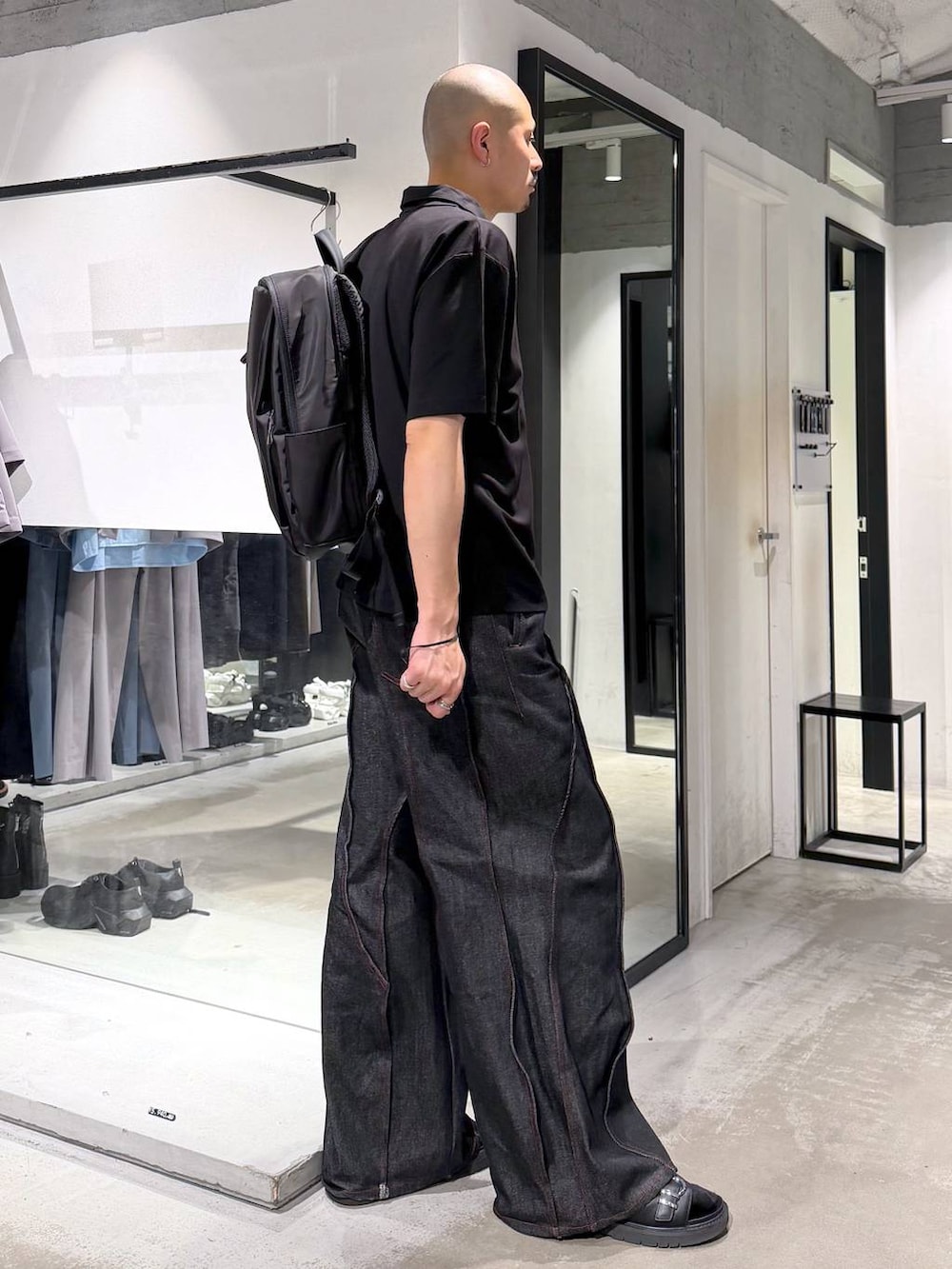 ブラック系のデニムパンツ、パープル系のTシャツ/カットソー、ブラック系のバックパック/リュックを着用したメンズの夏コーディネートの5枚目の写真
