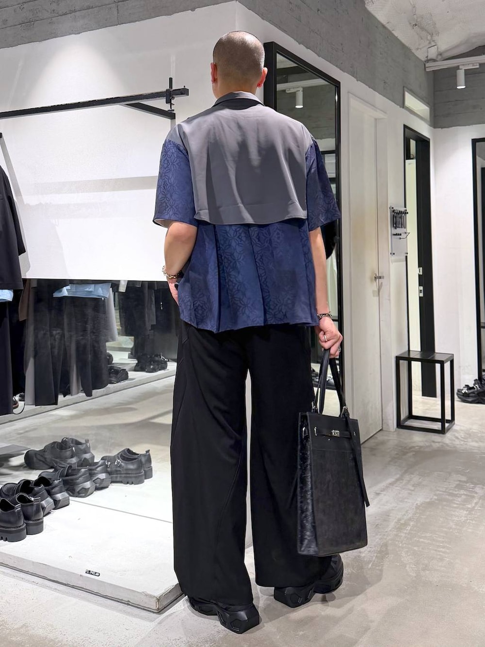 ブラック系のスニーカー、ホワイト系のTシャツ/カットソー、ブラック系のスラックスを着用したメンズの夏コーディネートの3枚目の写真